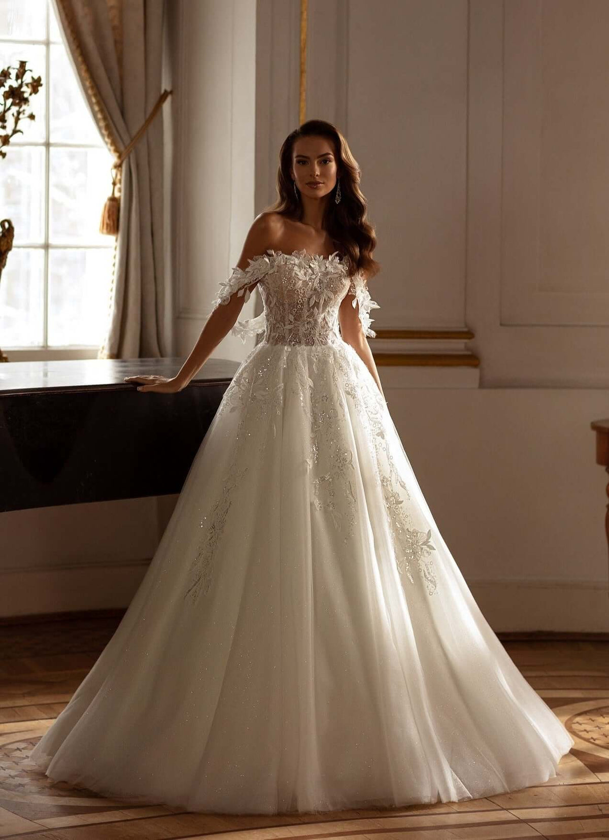 Model wearing a Becca Aline tulle lace wedding dress with off-the-shoulder straps and 3D lace details, showcasing elegance.