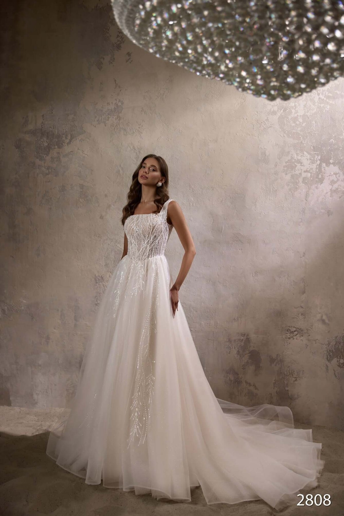 Aline wedding dress with basque waist and beaded bodice, featuring a built-in corset, in elegant bridal setting.