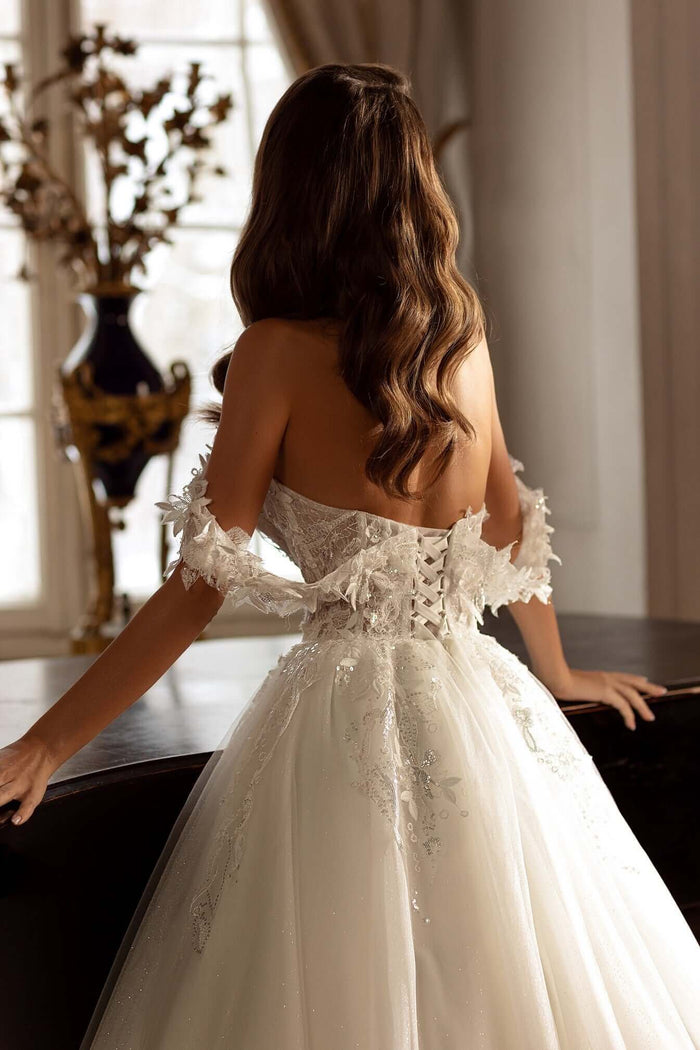Back view of Becca Aline tulle lace wedding dress featuring off-the-shoulder straps and 3D lace details.
