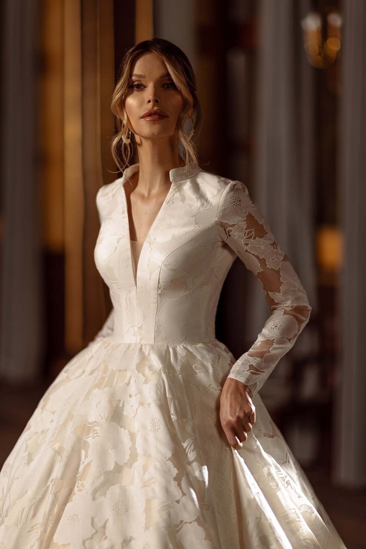Aline Wedding Dress with long sleeves and V neckline, made of modern floral lace fabric, shown on a model.