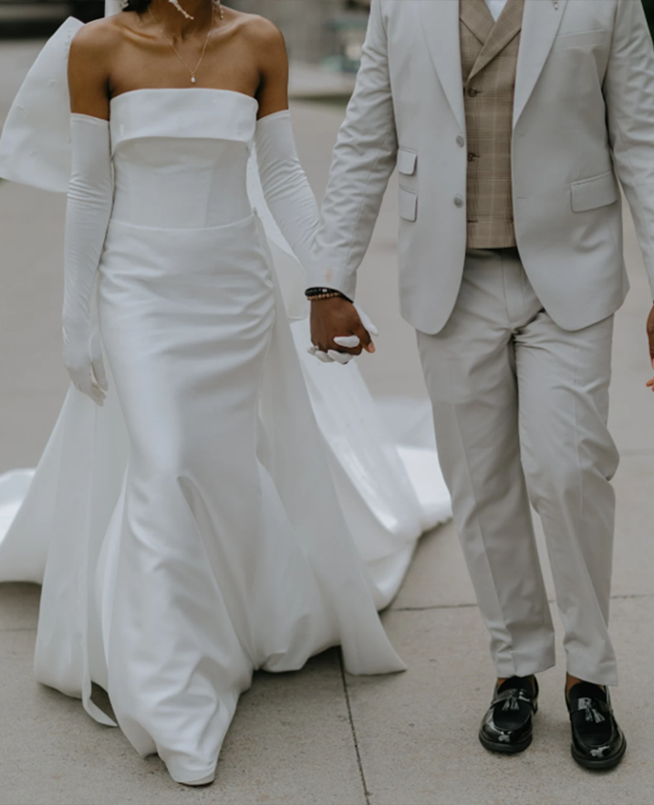 Real bride wearing a modern fitted custom wedding dress with long gloves