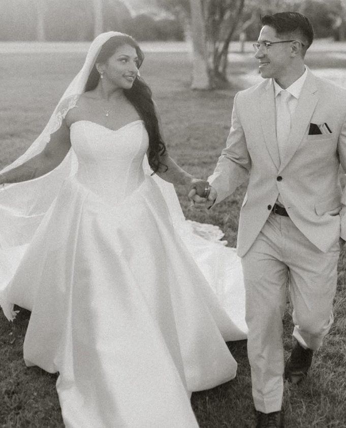 Bride and groom walking together with the bride wearing a custom ball gown wedding dress