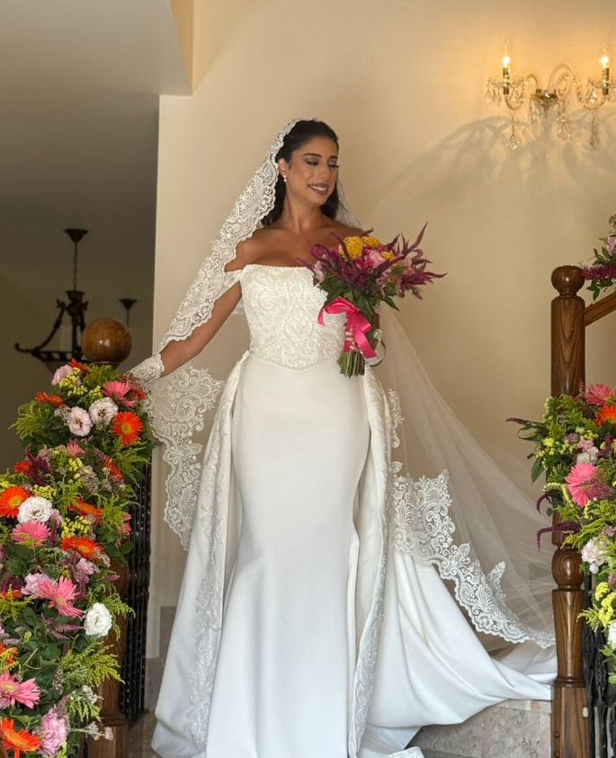 Real Poshfair bride wearing a custom fitted wedding dress with a long lace veil