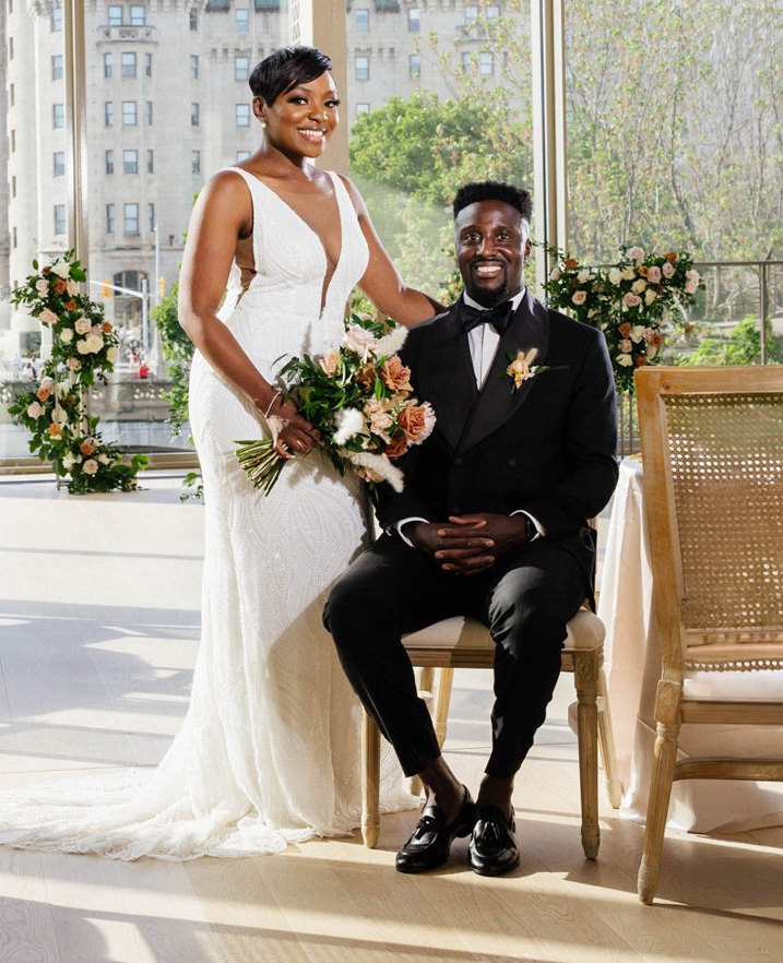 Bride wearing a modern custom wedding gown beside the groom at their wedding reception