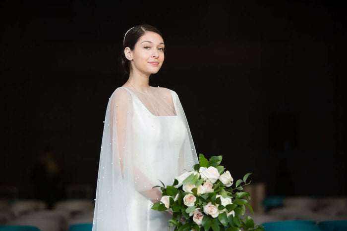 Lora II mermaid wedding dress on model with bouquet, showcasing elegant design and soft fabric, mermaid wedding dress